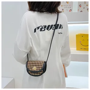 Kid's vintage houndstooth saddle bag with gold lock shown on model for size and fit