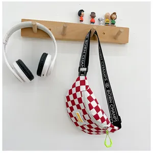 Detail view of red checkerboard kids chest bag with letter printed shoulder strap