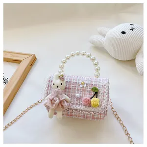 Détail du sac en tweed rose à carreaux avec anse en perles et poupée lapin mignonne