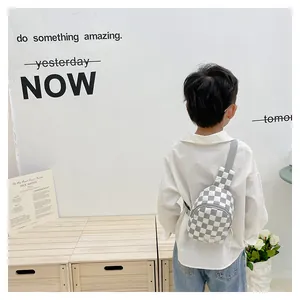 Detailed back view of a quilted checkerboard chest bag worn by a young child