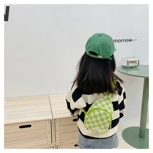 Detail of green checkerboard kids chest bag with FASHION patch and adjustable strap