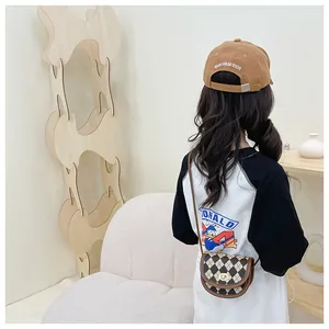 Close-up of a brown checkered mini round bag paired with a stylish children's casual outfit