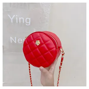 Detailed macro view of a red quilted leather round bag with a gold camellia flower clasp