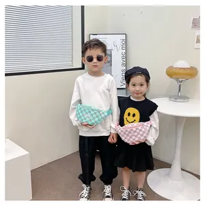 Close-up of kids checkered waist bags in mint green and pink with fashion labels