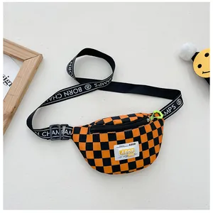 Detail of orange checkered kids chest bag with green zippers and lettered strap