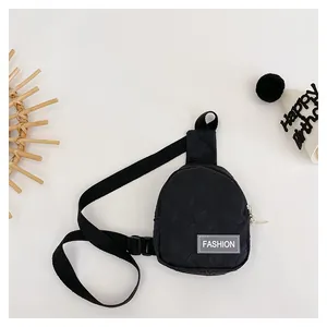 Detail of black checkered chest bag with textured fabric and adjustable buckle strap