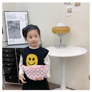 Detail of pink and grey checkerboard children's chest bag with FASHION label