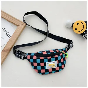 Detail of pink and blue checkered kids chest bag with ADDR tag and neon green zipper pull