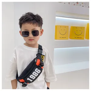 Close-up of black and orange kids chest bag with 1986 print and buckle detail