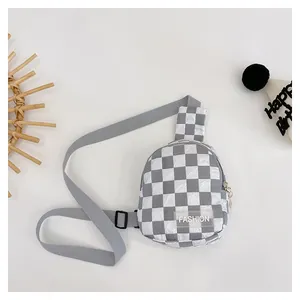 Detail of checkered boy's chest bag showing wrinkled texture and fashion rubber label