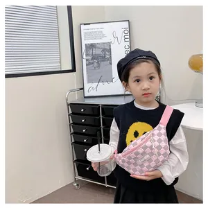 Pink checkered kids waist bag with fashion label shown on a child model with a sweater