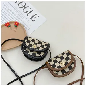 Detail of vintage checkered mini saddle bags with metal twist locks and leather straps