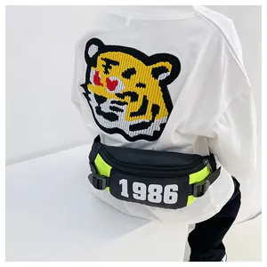 Detail of kids chest bag in black and neon yellow with number 1986 and adjustable strap