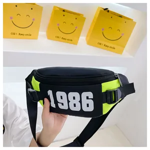 Detail of neon green and black kids chest bag featuring a white 1986 number print