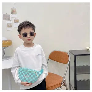 Detail view of mint green checkered kids chest bag with adjustable strap and fashion label