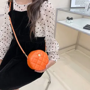 Kids quilted round crossbody bag in orange with flower charm and chain strap