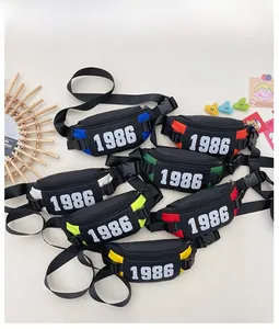 Flat lay of colorful nylon chest bags with 1986 logo and adjustable straps for kids