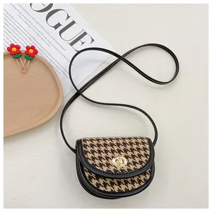Detail view of mini saddle bag featuring retro houndstooth pattern and gold twist lock