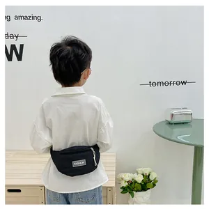 Close-up of a black quilted kids waist bag with a white zipper and fashion label logo