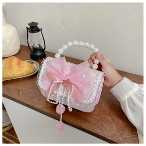 Detailed view of pink lace kids purse with pearl handle and sequin bow decoration
