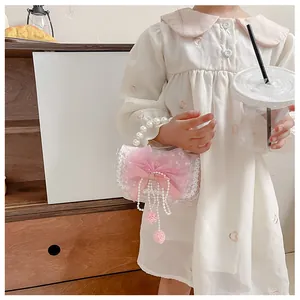 Detail of pink lace kids handbag featuring pearl handle and mesh bow decoration