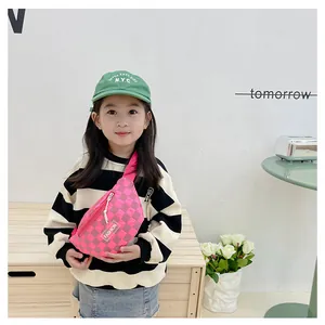 Pink checkered kids fanny pack with FASHION patch shown on a child model in a modern room