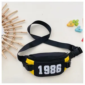 Detail of yellow and black nylon kids chest bag with 1986 print and adjustable strap