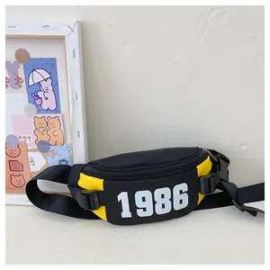 Close-up of black and yellow crossbody chest bag with 1986 print and buckle detail