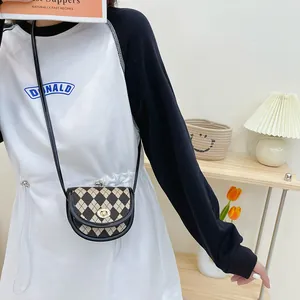 Girl's mini crossbody saddle bag with black and white checkerboard pattern and gold clasp