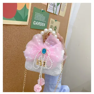 Detail der weißen gesteppten Mini-Tasche mit rosa Paillettenschleife und Perlengriff