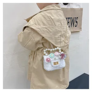 Close-up of girls' tweed mini bag featuring pearl handle and 3D floral accents