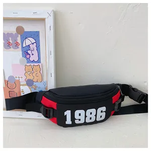 Close-up of a stylish black and red kids waist bag featuring a bold white 1986 logo