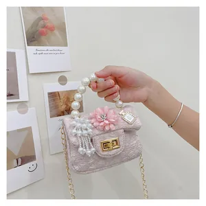 Detail of pink jacquard mini bag with pearl handle and floral perfume charm accessories
