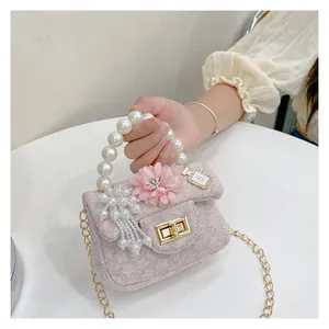 Close-up of pink textured mini bag with pearl handle and floral decoration
