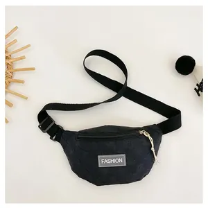 Detail view of black quilted nylon kids chest bag featuring fashion label and white zipper pull