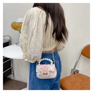 Detail of pink girls mini crossbody bag with flower charm and pearl chain handle