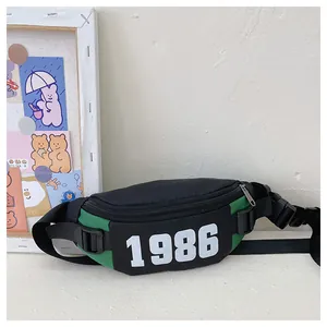 Detail of green and black kids waist bag with 1986 print and adjustable nylon strap