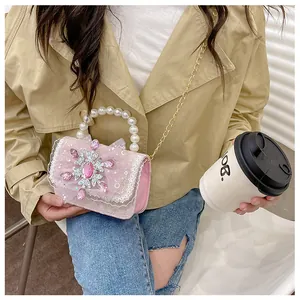 Pink girls' pearl handbag with snowflake gem and lace details on a golden chain strap