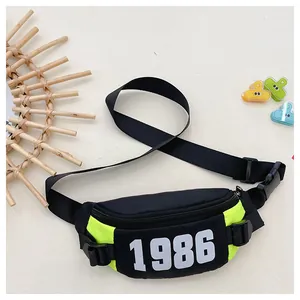 Close-up of black and neon yellow kids chest bag with 1986 print and adjustable strap