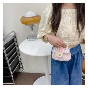 Detail of pink floral handbag with pearl handle, gold chain and number 5 pendant