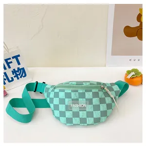 Detail of mint green and dark grey checkered belt bag with a clear fashion label