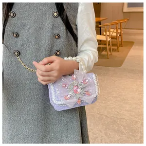 Detail of purple glitter kids handbag with crystal snowflake and pearl handle