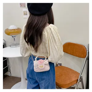 Pink girl's pearl bag shown on a young model with gold chain and lace texture