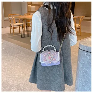 Detail of lavender mini pearl bag with lace edge and rhinestone snowflake pendant