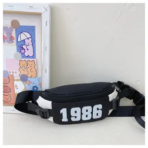 Detail of checkered kids chest bag featuring white 1986 print and adjustable strap