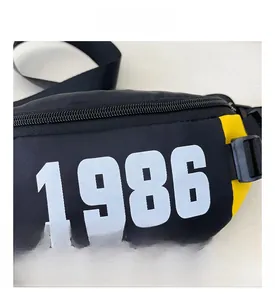 Detail showing durable black and yellow nylon chest bag with 1986 print and buckle