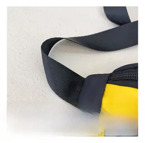 Detail view of durable black nylon webbing and reinforced stitching on a yellow kids chest bag