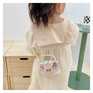 Detail of pink girls mini crossbody bag with 3D floral accents and pearl handle