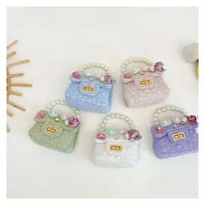 Detailed look of five colorful mini bags featuring pearl handles and floral decorations