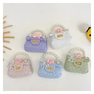 Detail of five mini handbags with pearl handles and floral accents in pastel colors